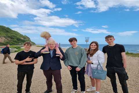 Boris Johnson carries son Wilfred, 4, on his shoulders as they pose with locals during seaside..