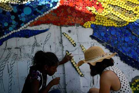 Venezuelan muralist makes use of recycled plastic to mild up Caracas suburb – World