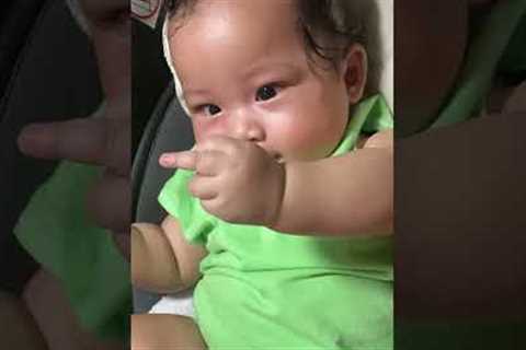 Funny baby points middle finger at mom