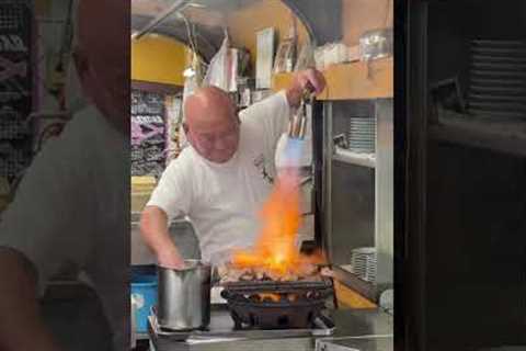 Fast-handed chef uses flamethrower to grill chicken while sprinkling on water to stoke flames