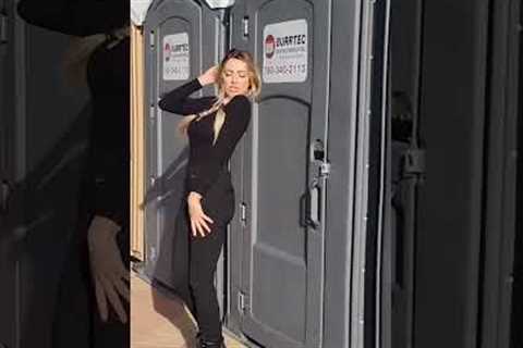 Influencer posing against porta potty get hit by door when occupant kicks it open